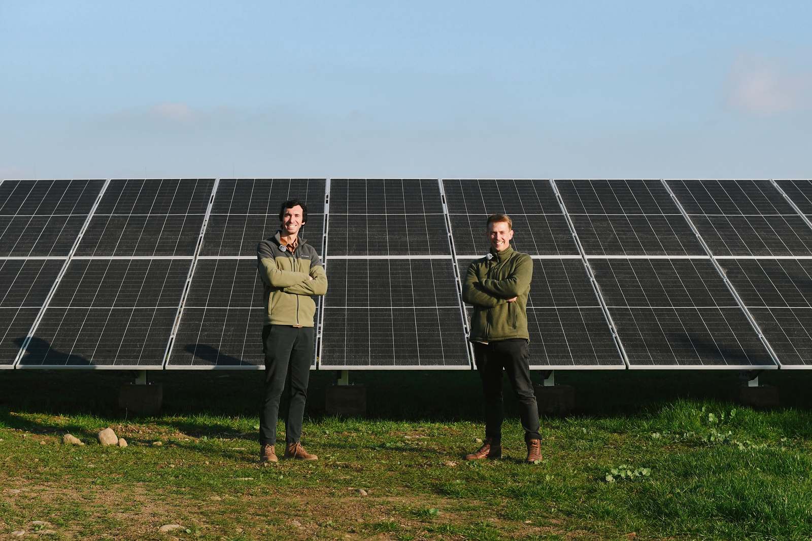 Dos personas frente a la planta solar de Agrizano, en Curicó, con las filas de paneles montados sobre estructura a suelo