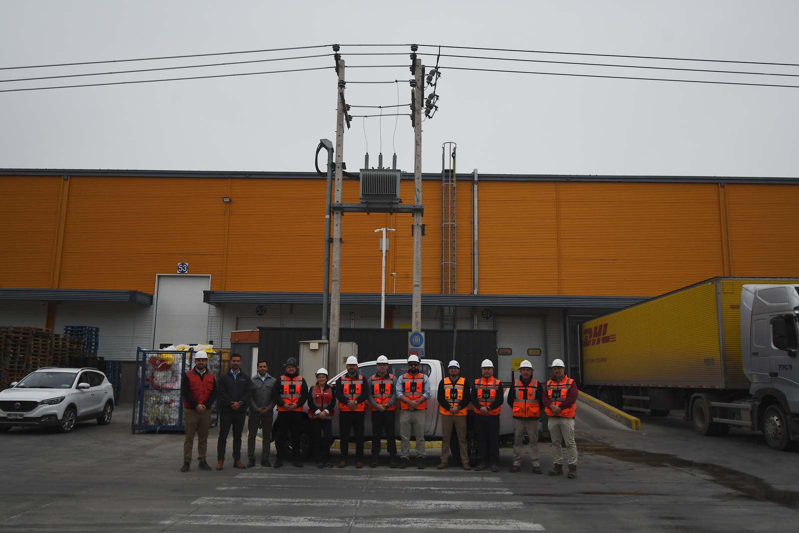 Equipo de Rising Sun y del cliente frente a la bodega de Bodenor, con camiones operando en los andenes de carga