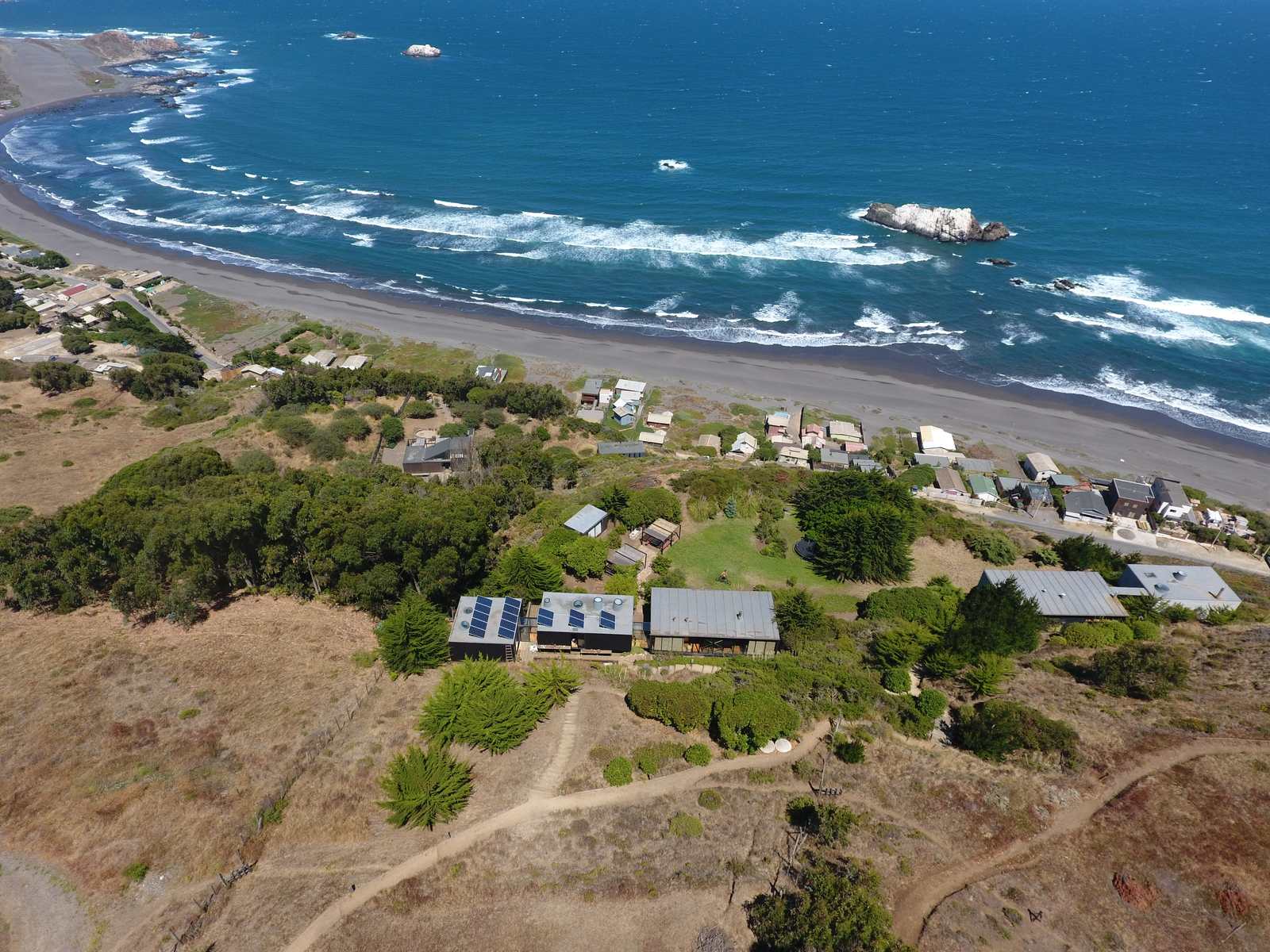 Vista aérea de la costa de Matanzas, en la comuna de Navidad, con paneles solares sobre el techo de la primera instalación de Rising Sun en Chile
